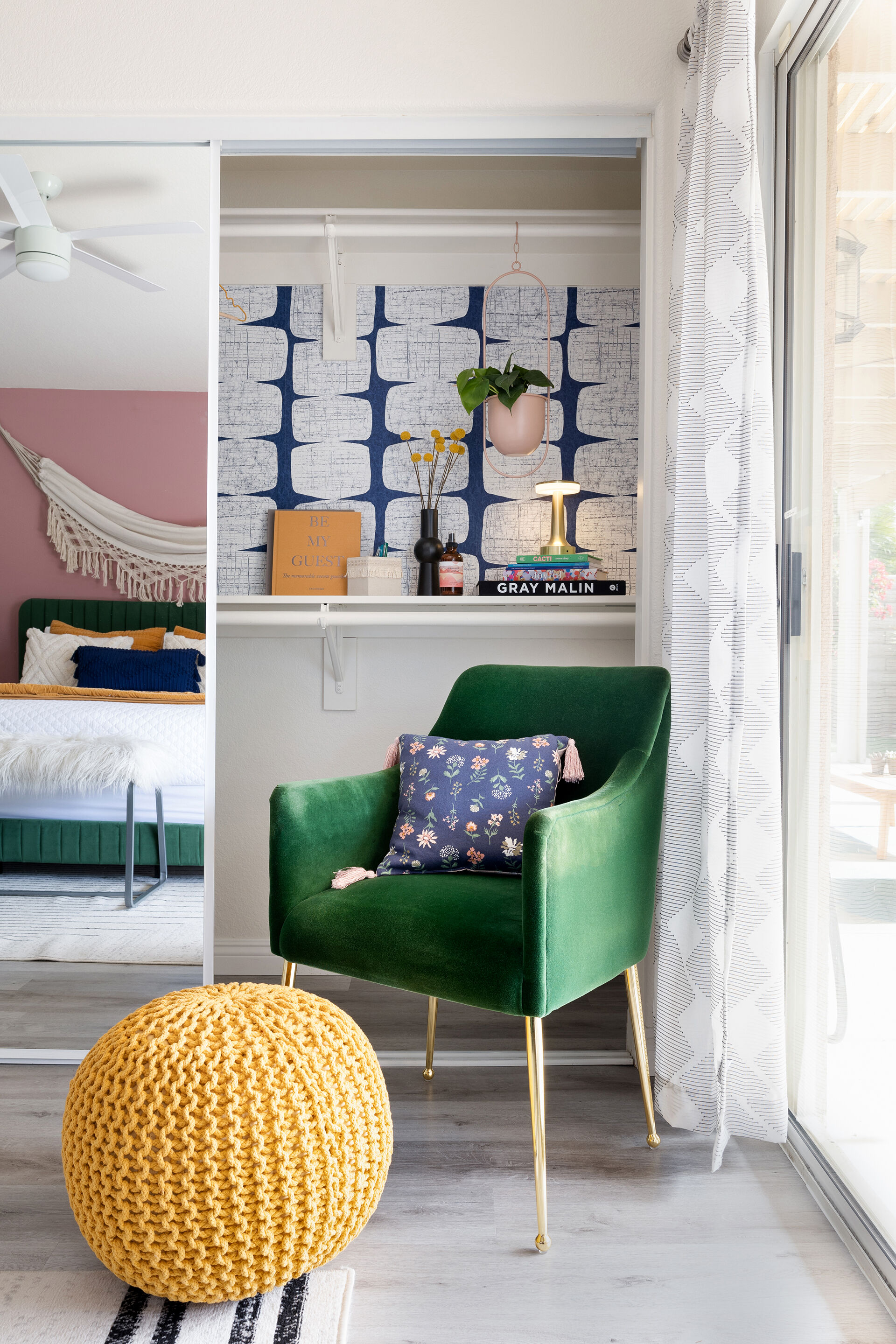 Full bedroom with wallpaper accent wall and velvet armchair at The Cozy Cactus vacation rental in Indio California