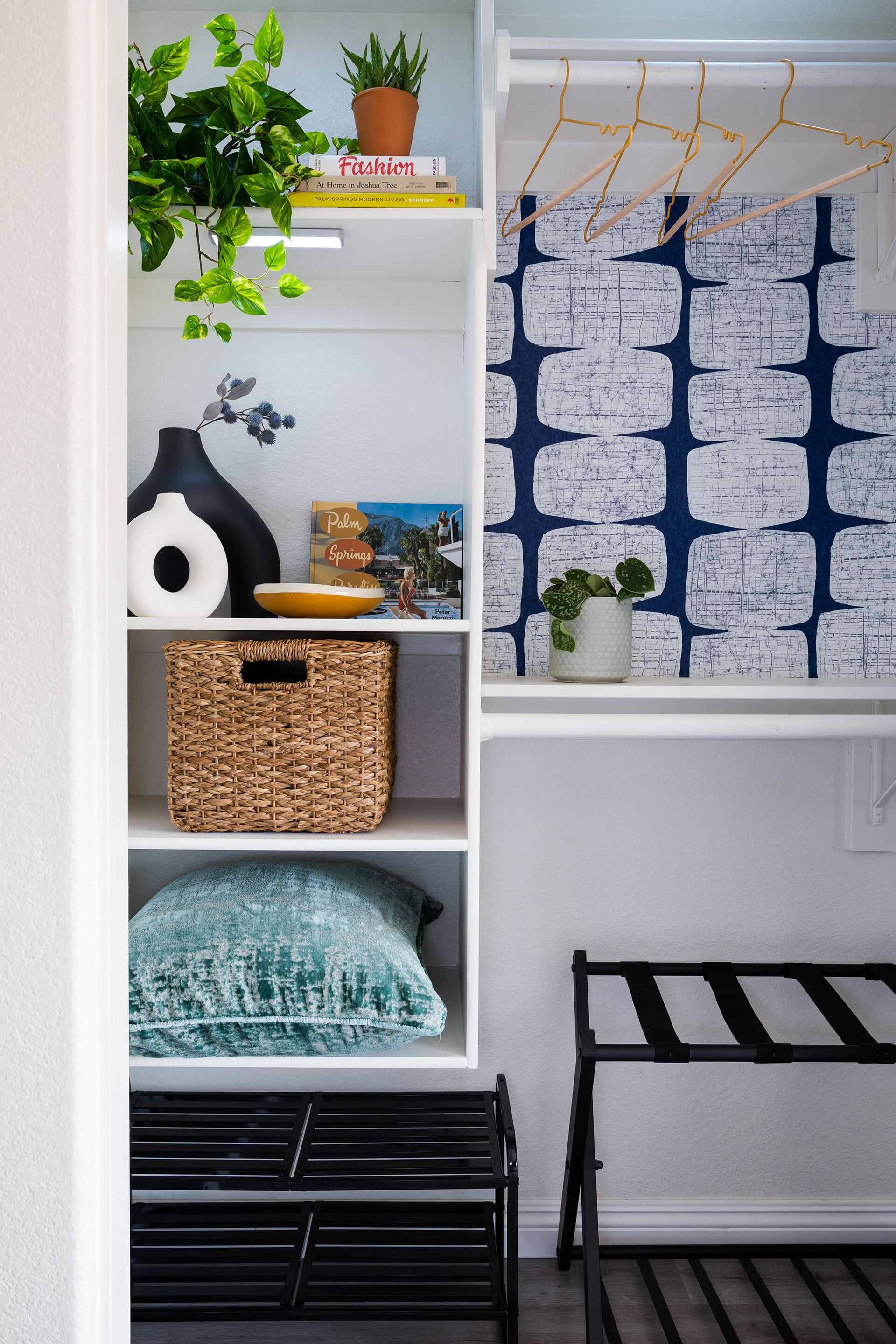Styled open closet at The Cozy Cactus vacation rental in Indio California with organized shelves and patterned wallpaper