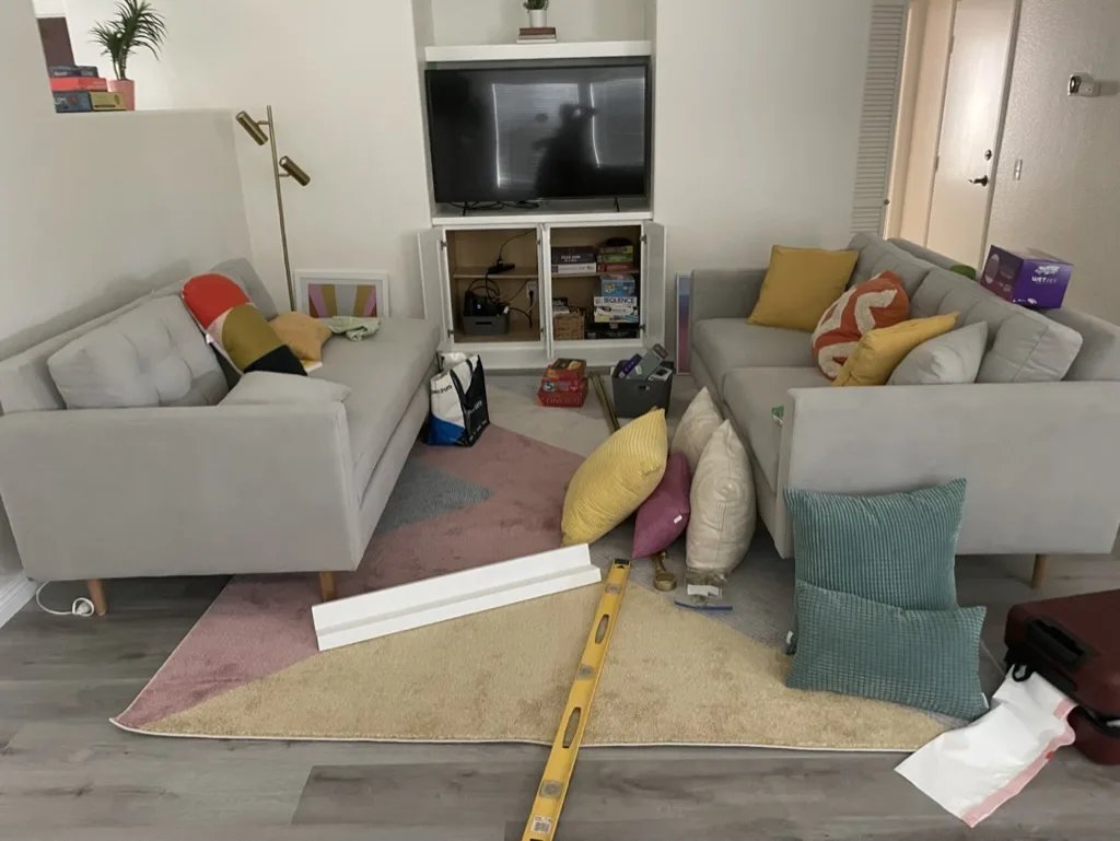 Vacation rental living room mid-staging with pillows and decor items in process before photo shoot setup