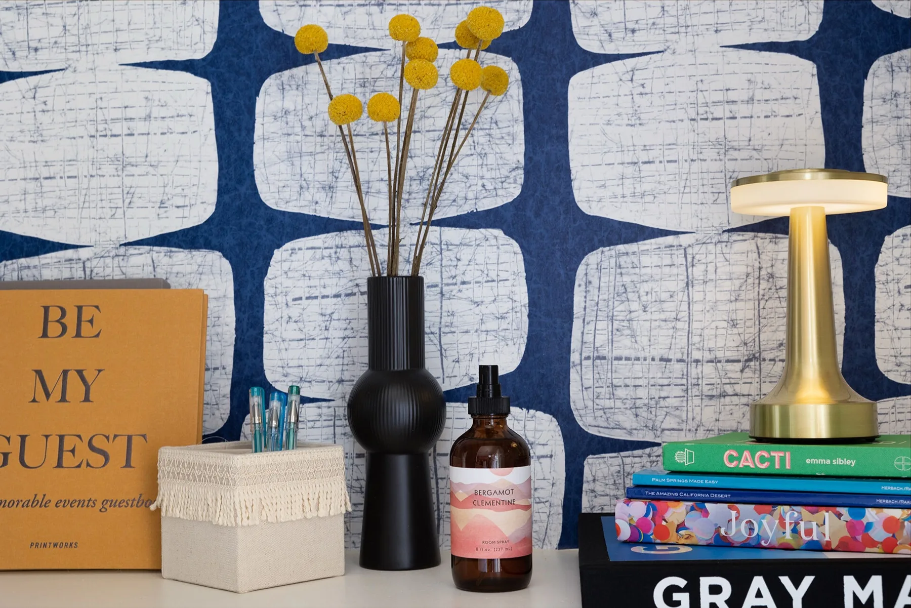Styled vacation rental reading nook with books, plant, and throw blanket perfectly arranged for photography