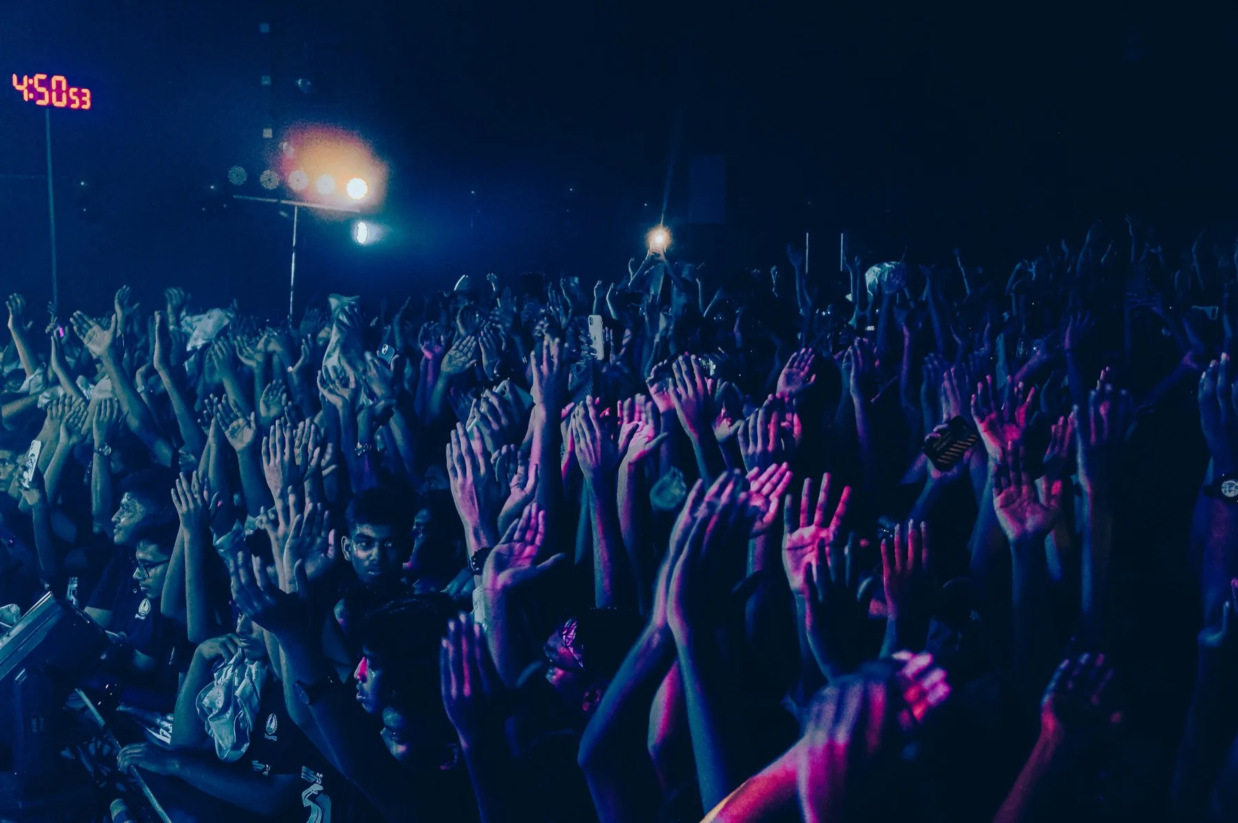 Concert crowd with hands raised at a music festival at night