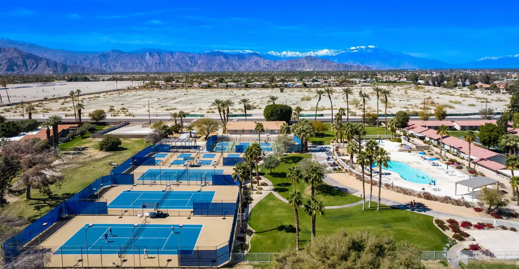 Aerial view of Indian Palms Country Club pickleball courts, tennis courts, and community pool in Indio CA