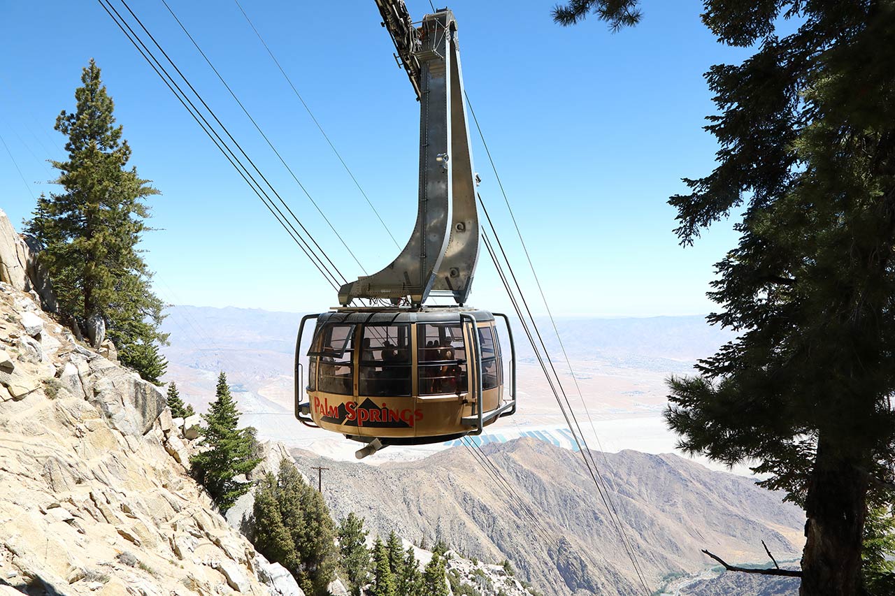 Palm Springs Aerial Tram car ascending the cliffs of Chino Canyon with Coachella Valley in the background