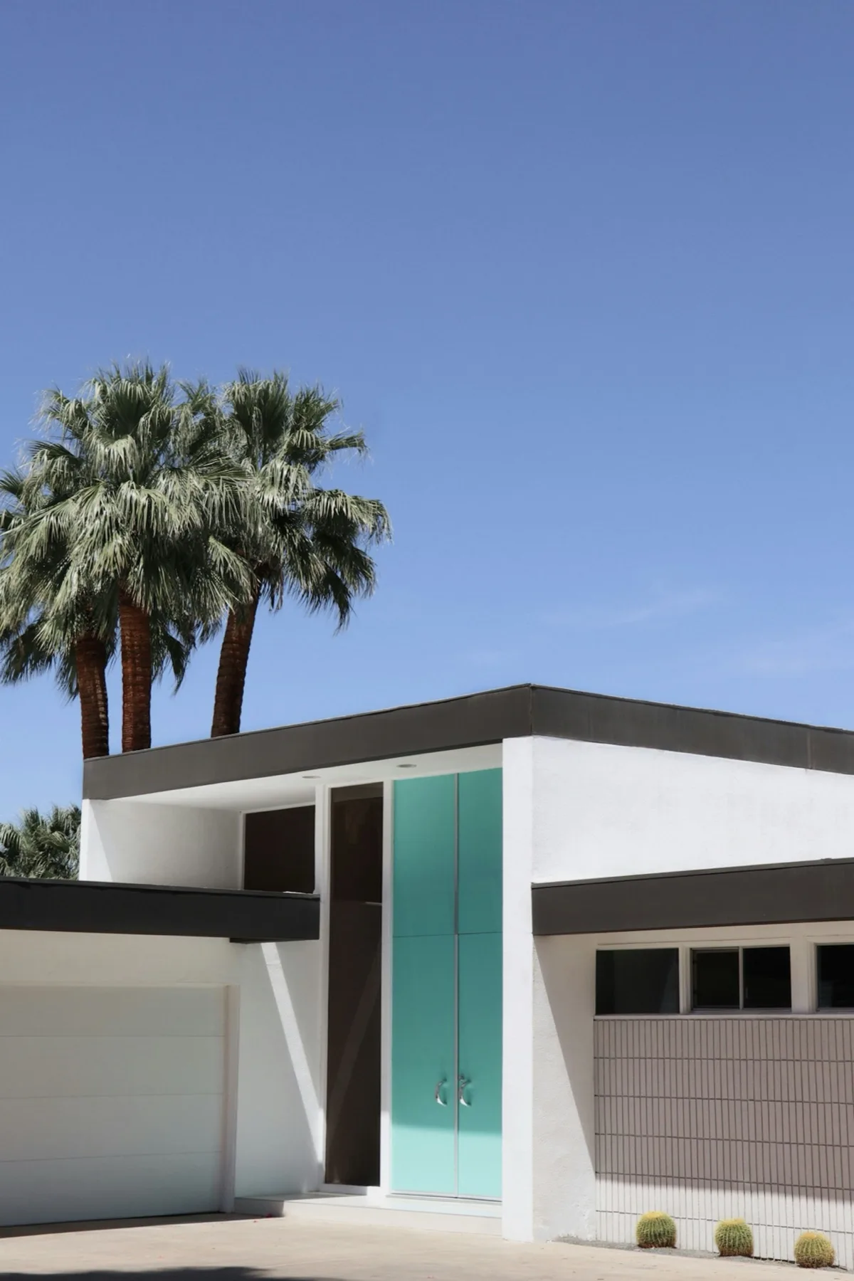 Teal door on a mid-century modern home in Palm Springs with cacti in front