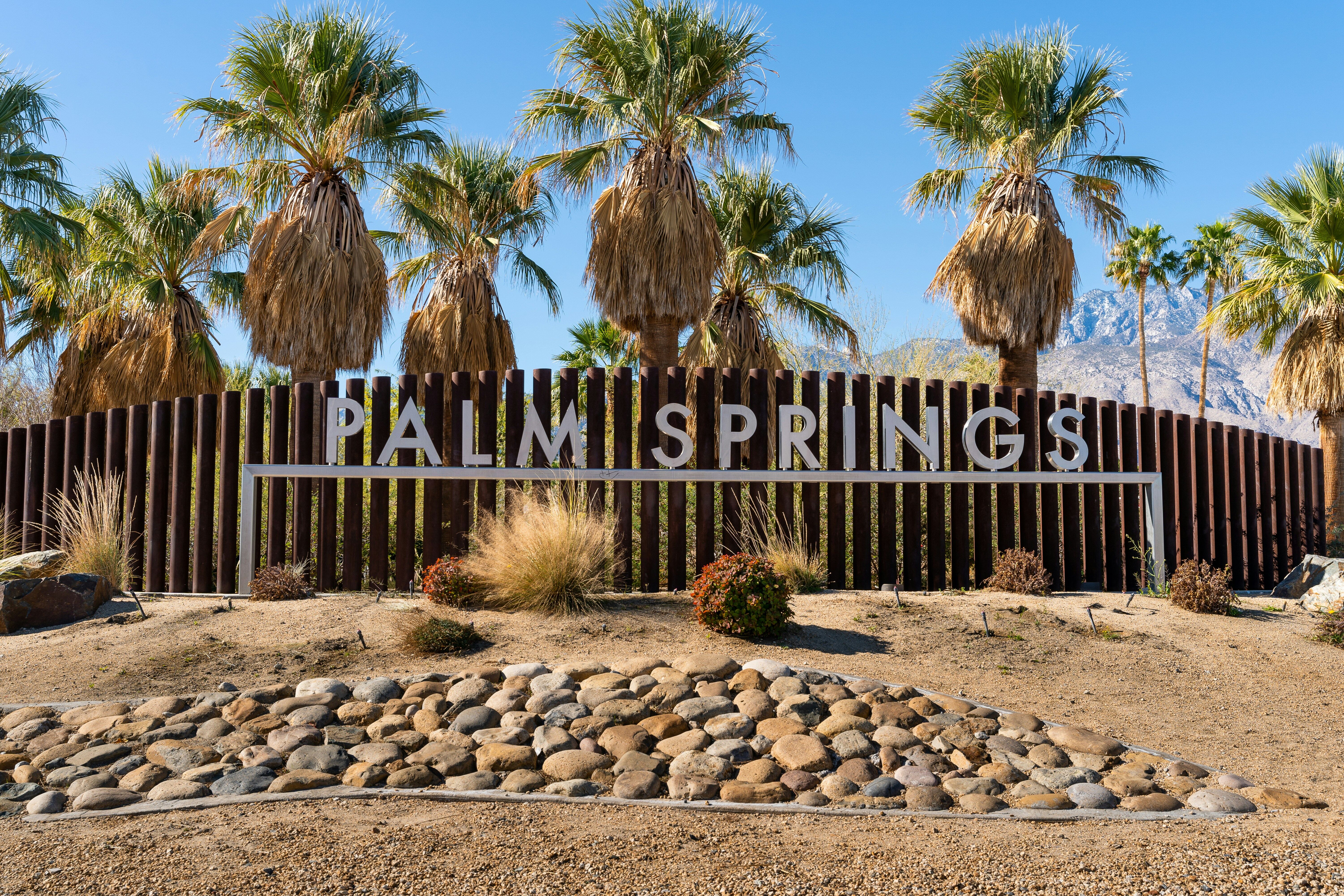 Palm Springs welcome sign with palm trees and San Jacinto mountains