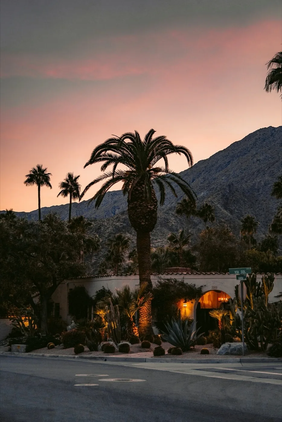 Desert sunset over a Palm Springs street with palm trees and San Jacinto Mountain silhouette