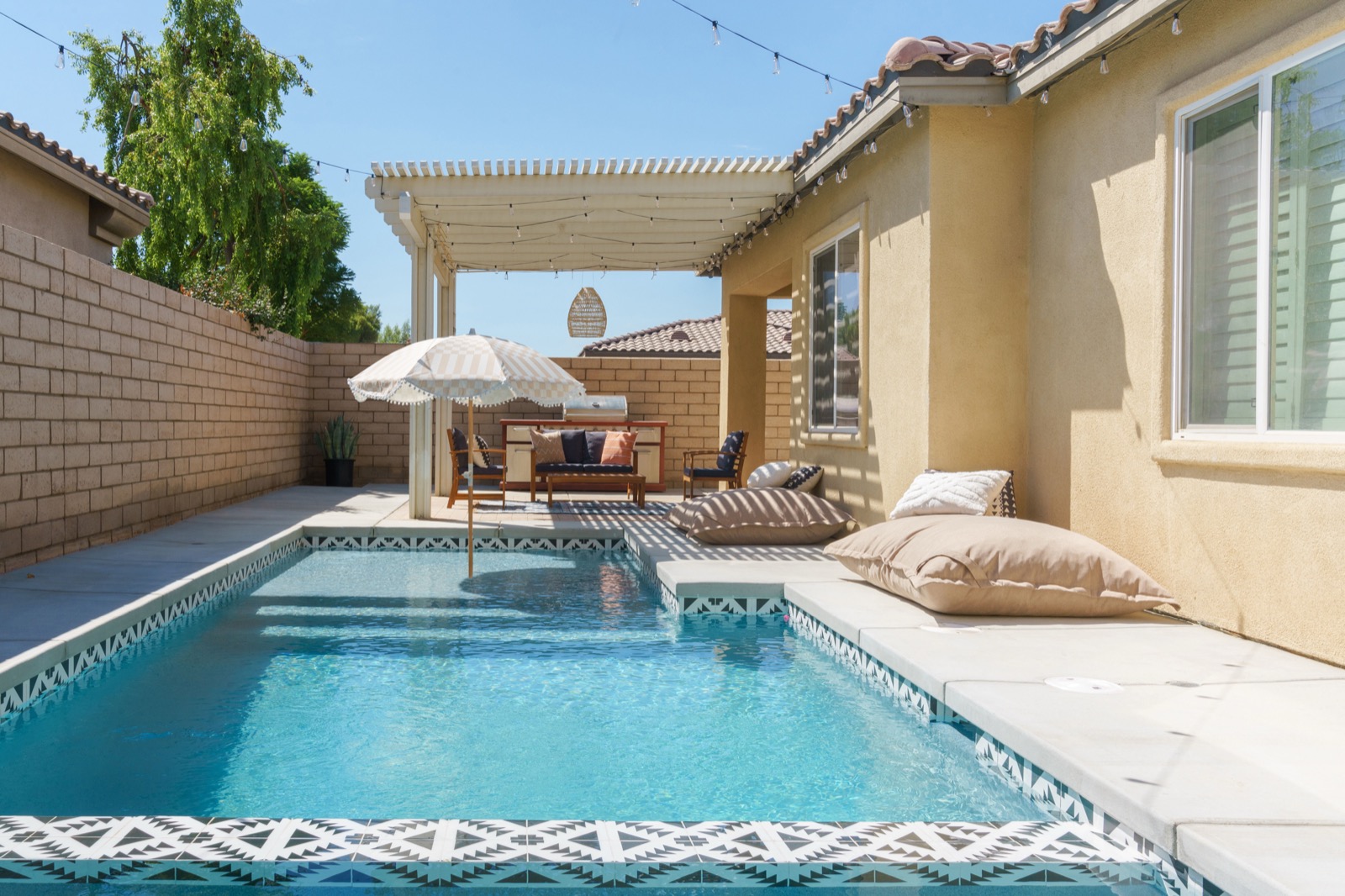 Private pool and covered patio at Terra Luz vacation rental in Indio CA with string lights and outdoor seating