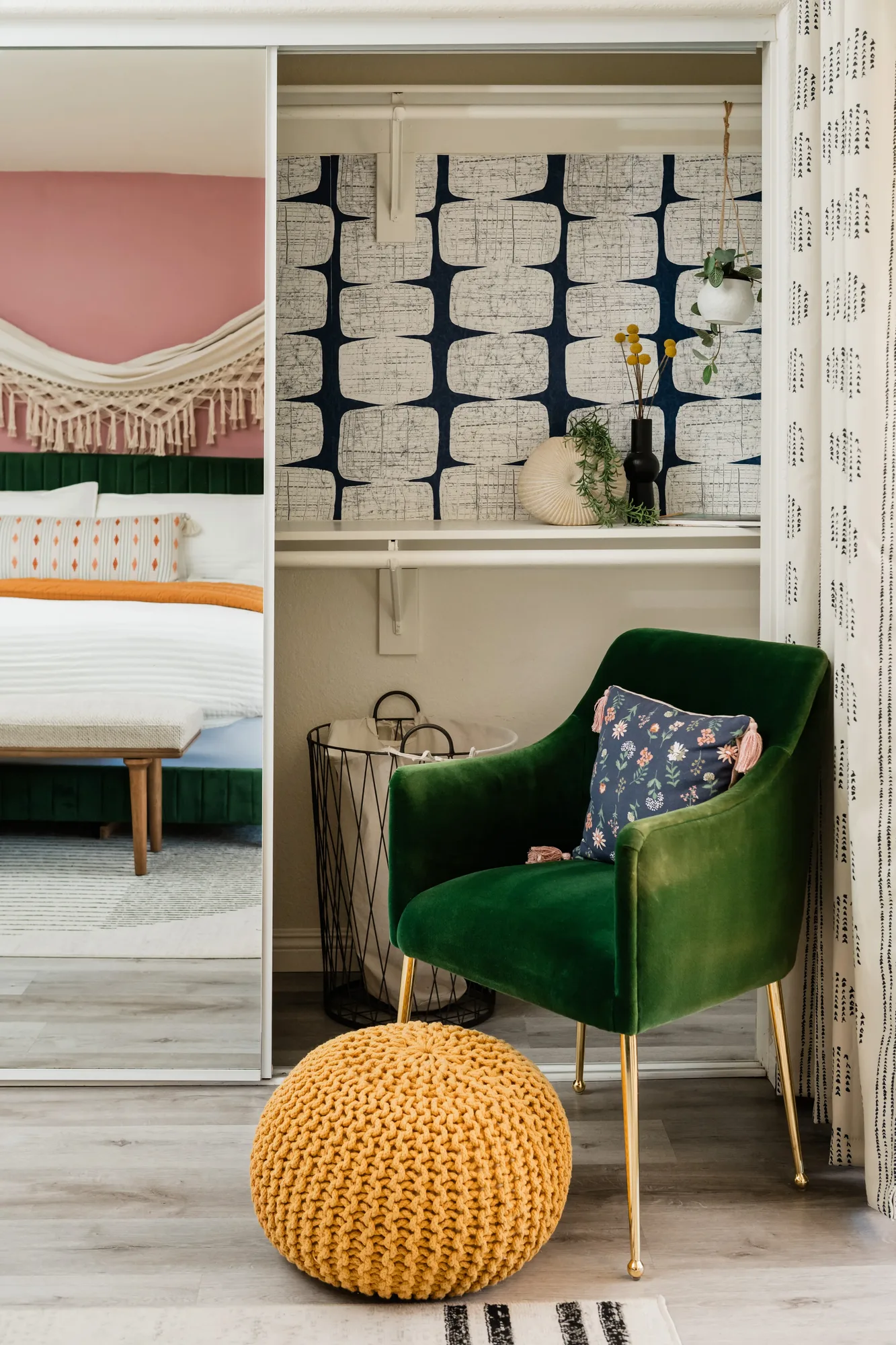 Cozy Cactus primary bedroom sitting area with green velvet chair and navy graphic wallpaper closet detail