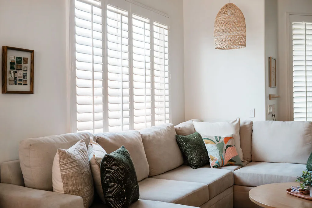 Terra Luz living room with rattan daybed and tropical plant at window in warm afternoon light