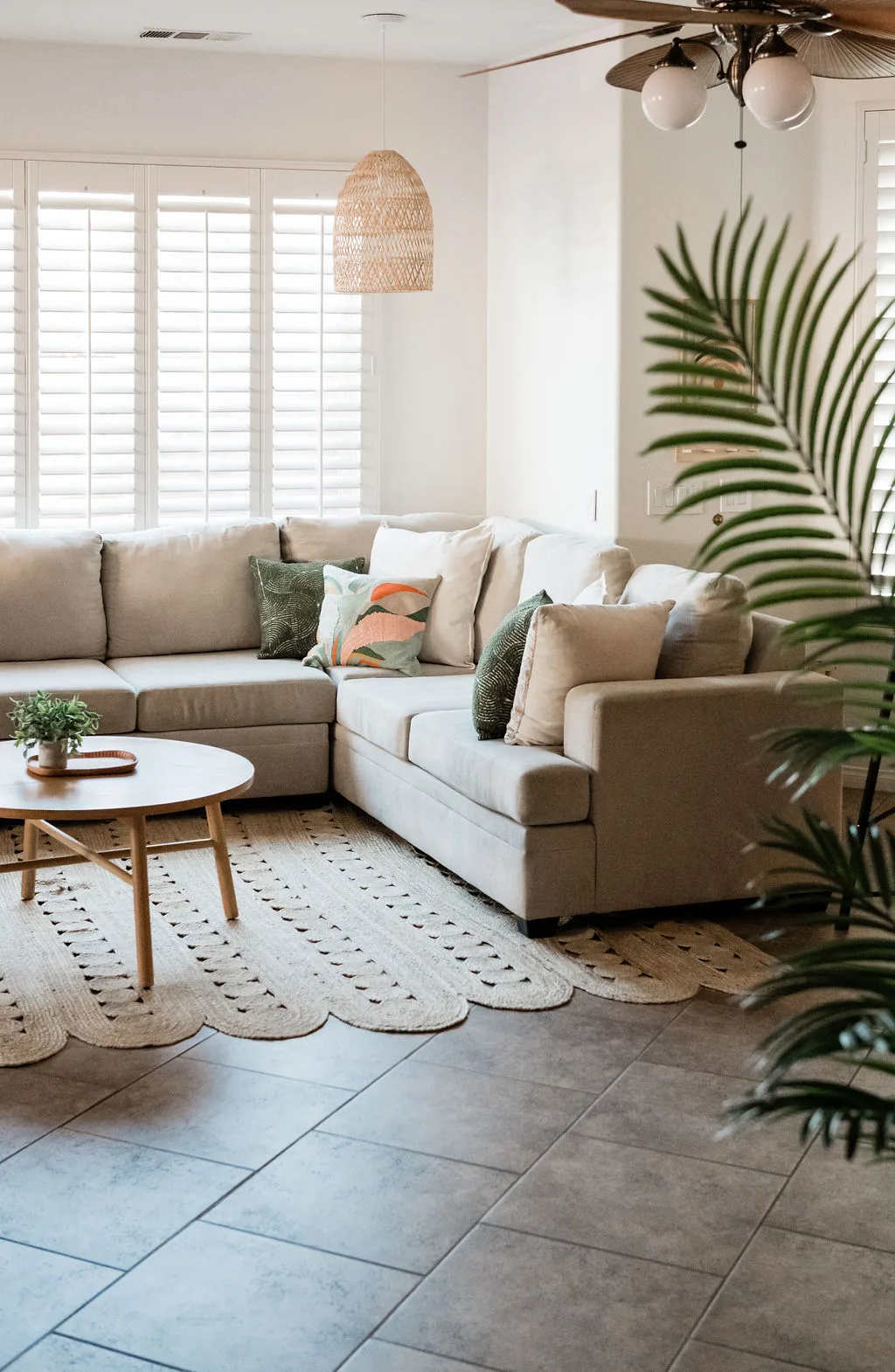 Terra Luz living room with rattan furniture, tropical plants in blue pots, and warm afternoon desert light