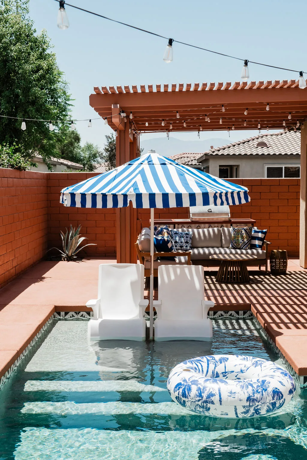 Terra Luz Kahlo blue saltwater pool with in-water sun shelf loungers and Desert Marigold umbrella