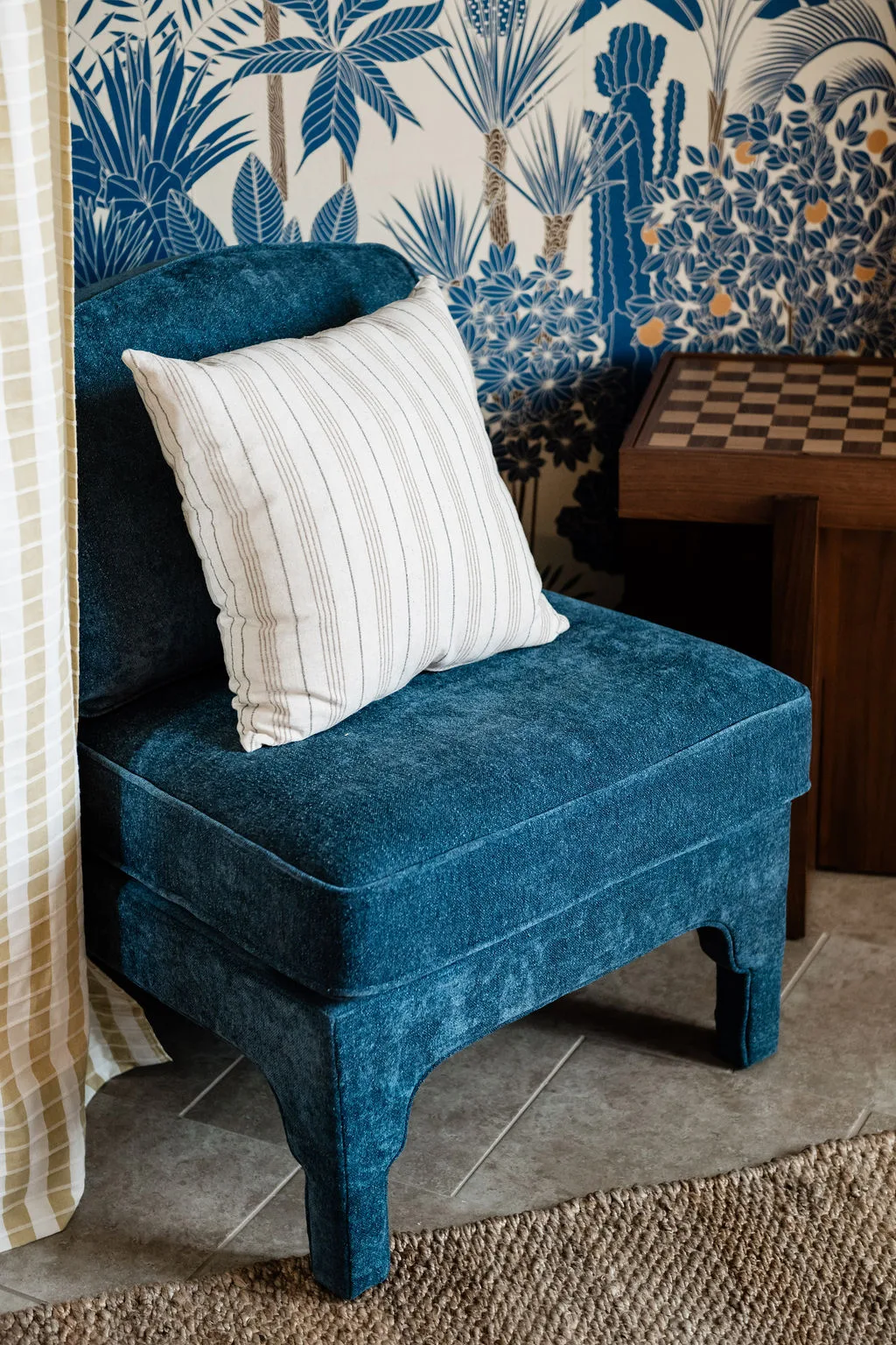 Terra Luz wallpaper bedroom blue velvet slipper chair with checkerboard side table and Rebel Wall wallpaper