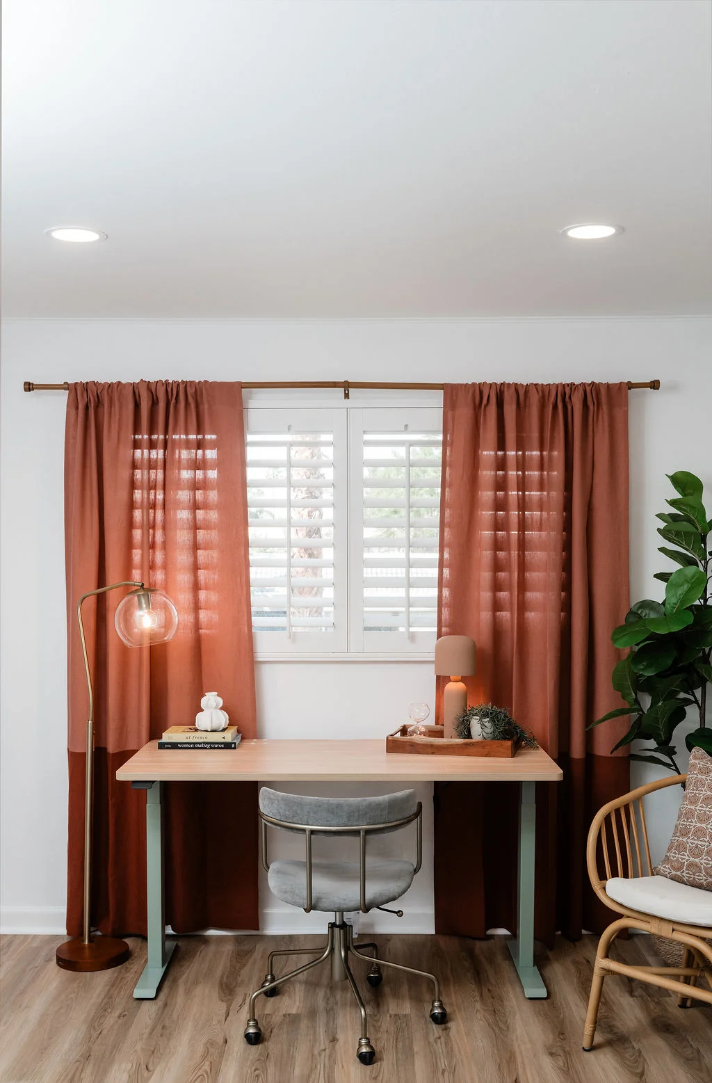 The Sundune Palm Springs second bedroom with rust linen curtains, king bed, rattan chair, and fiddle leaf fig