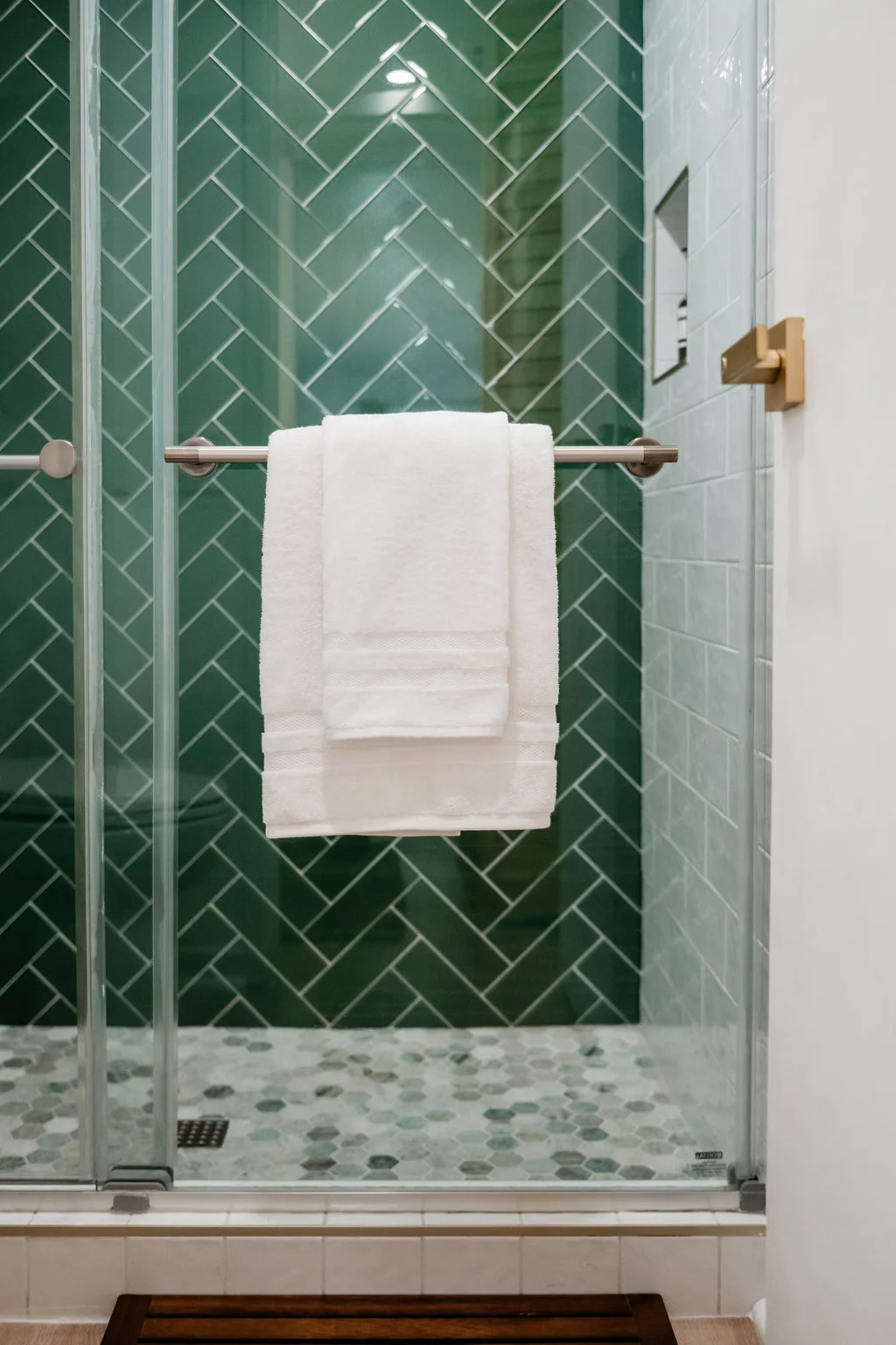 The Sundune Palm Springs second bathroom green herringbone tile shower detail with gold fixtures