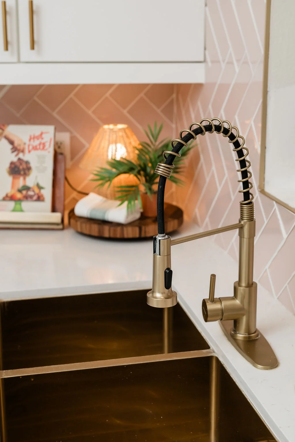 The Sundune Palm Springs kitchen gold spring faucet detail with pink herringbone tile