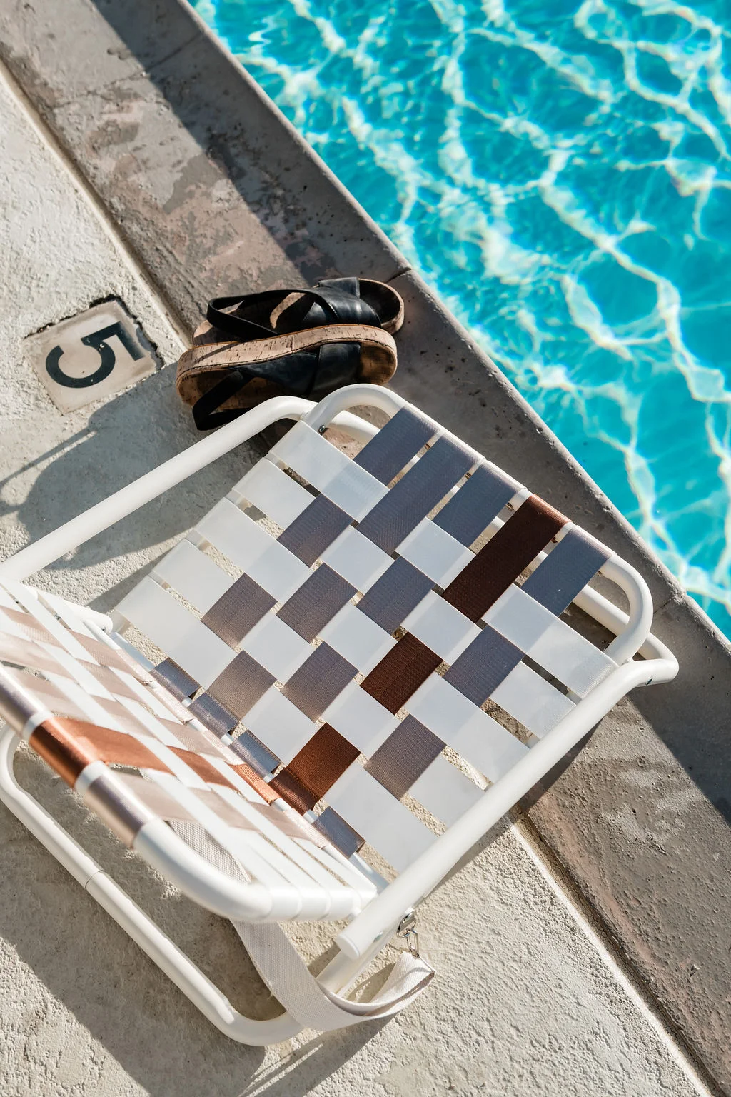 The Sundune Palm Springs pool lounge chair close-up with sandals on deck